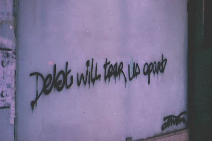 Graffiti that says "Debt will tear us apart"